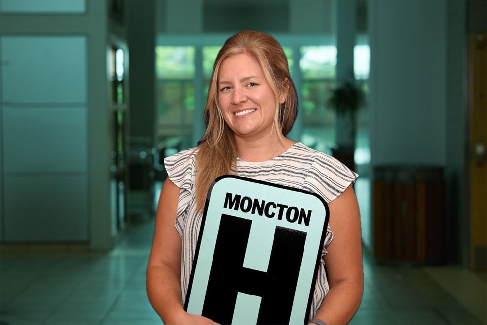 Annick Ouellette Holding H Sign and Smiling at camera