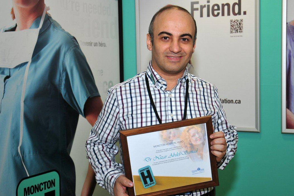 Dr. Nizar Abdel Samad holding a hospital hero plaque