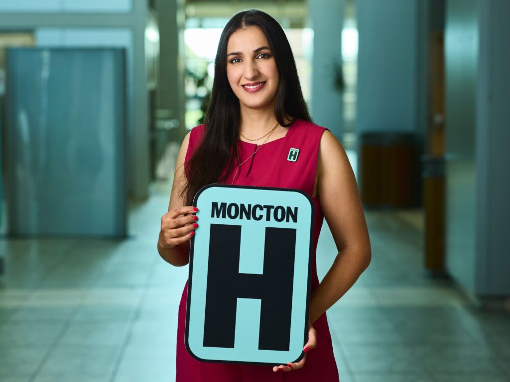 Sophia Mapara Holding H Sign and Smiling at camera