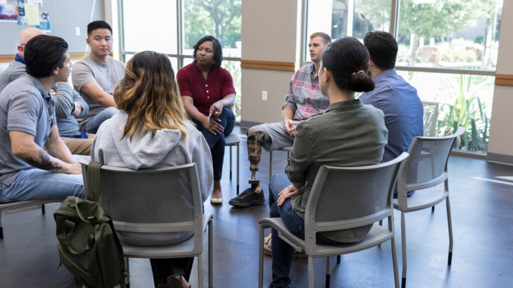 Group of people sitting in chairs in a support circle